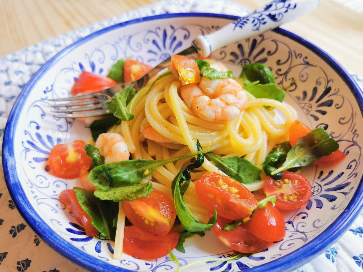 Italian cold spaghetti salad with shrimp from Marche in blue and white bowl.