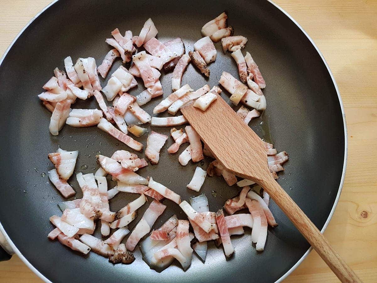 Small slices of guanciale in frying pan.